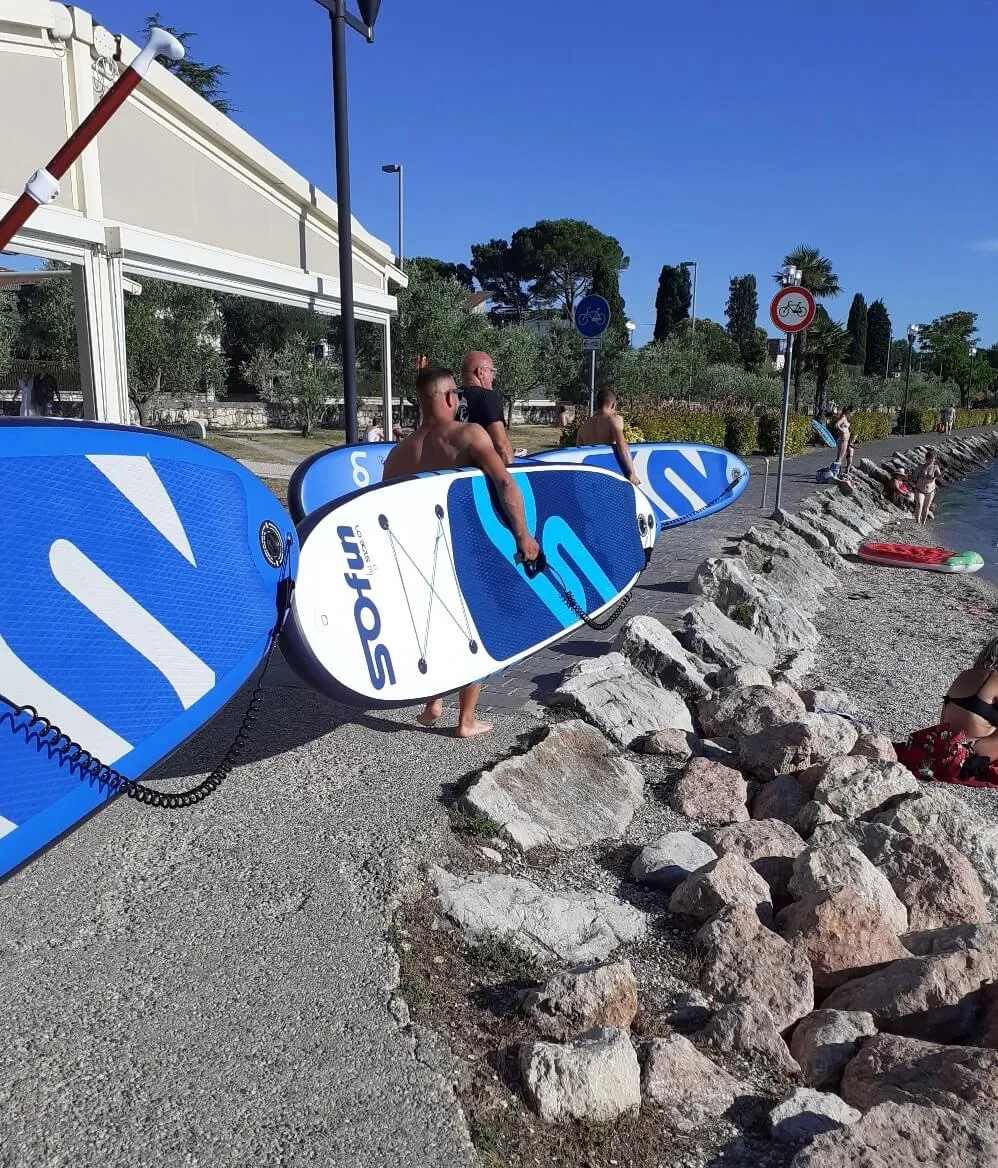 persone-che-trasportano-tavole-da-sup-gonfiabili